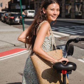 Vrouw op weg fiets aan de hand